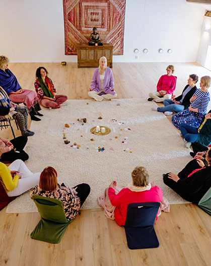 Groep deelnemers tijdens opleiding of meerdaags programma in de meditatiezaal van De Maanhoeve in Drenthe